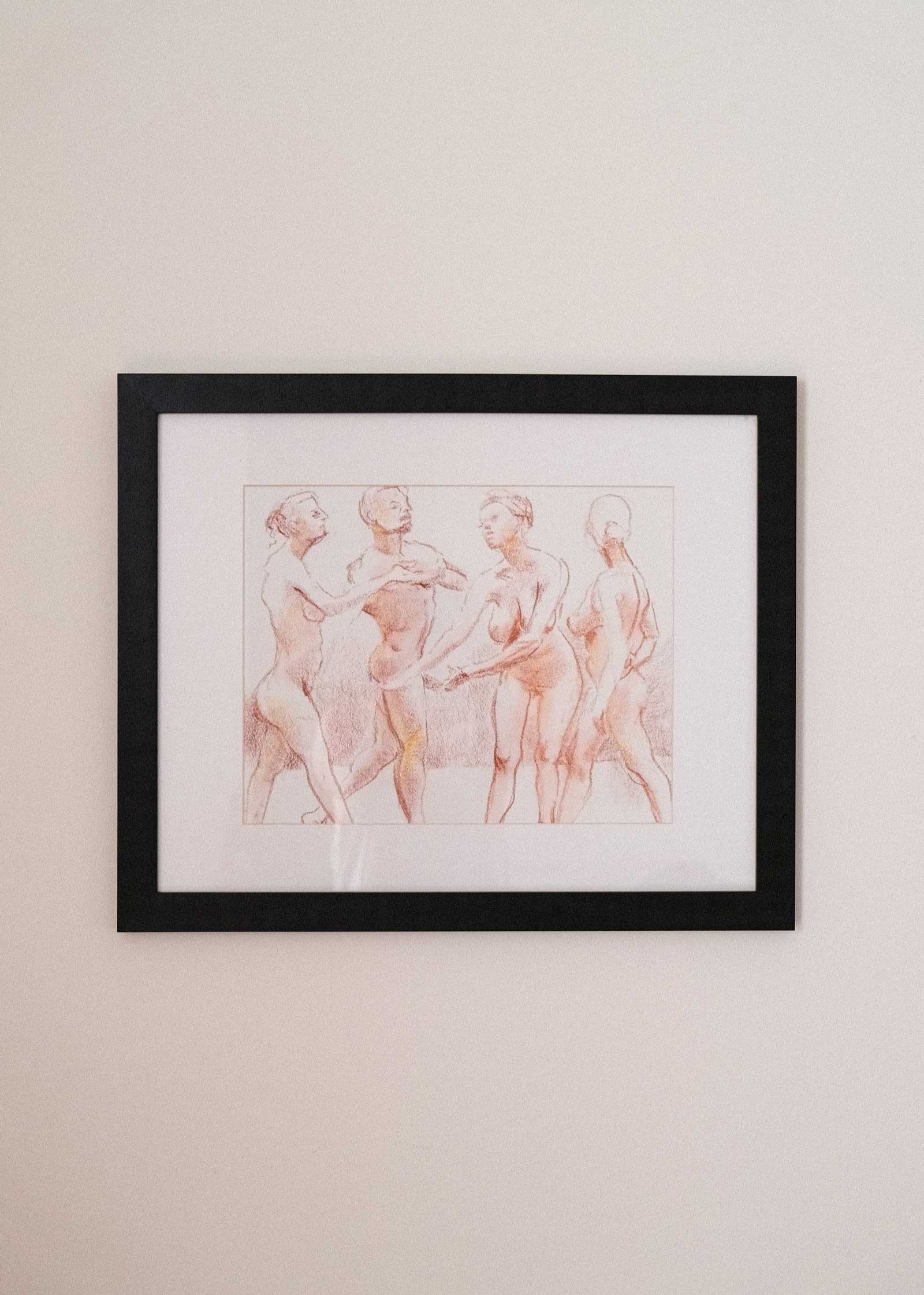 Framed artwork of three nude figures on a beige wall