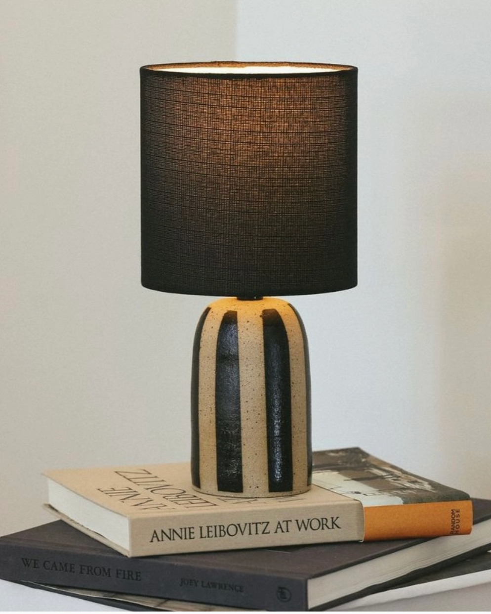 Handmade ceramic lamp with black stripes on a natural clay finish