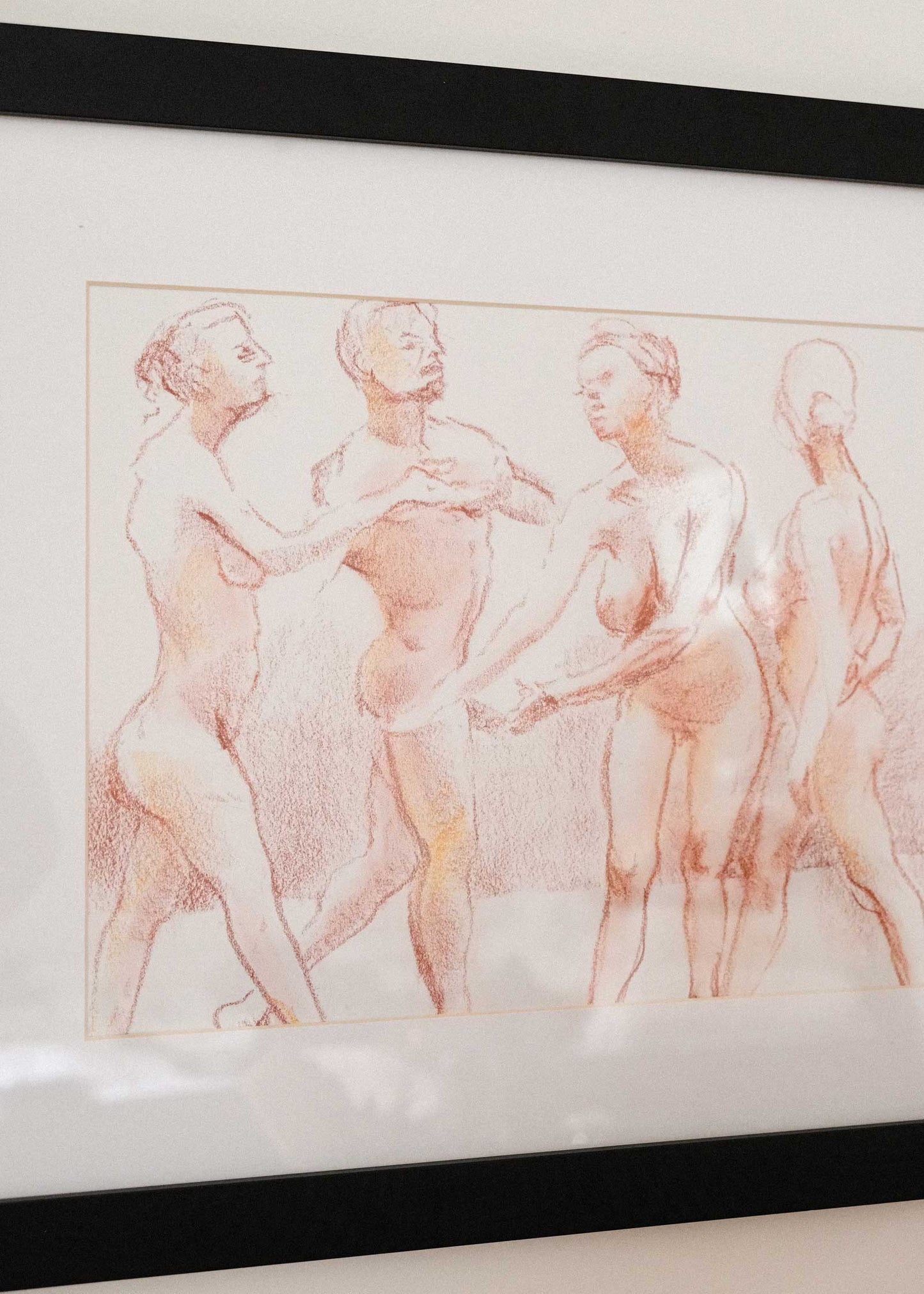 Framed artwork of classical nude figures on a white wall